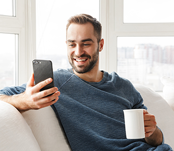 Hombre tomando cafe y viendo celular Hombre tomando cafe y viendo celular